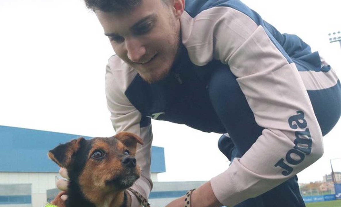 Álvaro García, con uno de los perros de la asociación Vida con perros para la campaña #FuenlaAdopta | CF Fuenlabrada